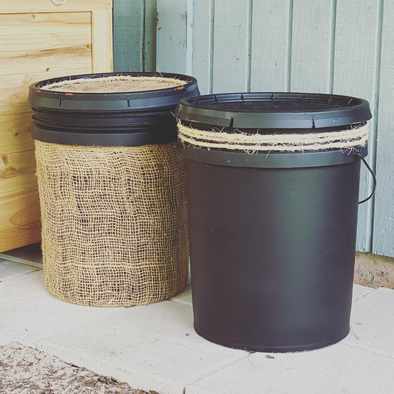 5-gallon buckets that have been painted black and decorated with burlap and rope